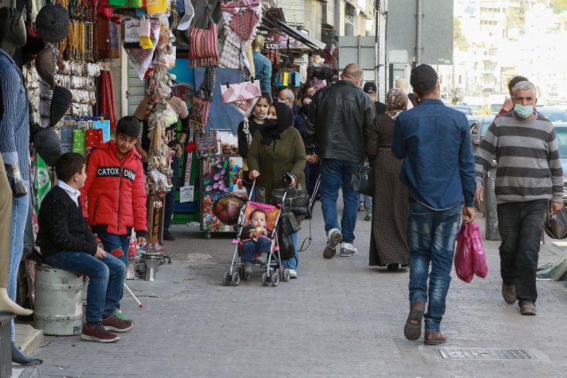 People walk past shops on a market street in Jordan's capital Amman, on April 5, 2021, after a rare security operation took place in the country. - Jordan's Prince Hamzah, accused by the government of a "wicked" plot against his elder half-brother King Abdullah II, insisted he will not obey orders restricting his movement. The government has accused him of involvement in a seditious conspiracy to "destabilise the kingdom's security", placed him under house arrest and detained at least 16 more people. (Photo by Khalil MAZRAAWI / AFP) (Photo by KHALIL MAZRAAWI/AFP via Getty Images)