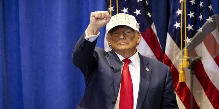 TOPSHOT - Former US President and 2024 Republican presidential hopeful Donald Trump raises his fist at a "Commit to Caucus" event at Simpson College in Indianola, Iowa, on January 14, 2024. (Photo by Christian MONTERROSA / AFP) (Photo by CHRISTIAN MONTERROSA/AFP via Getty Images)