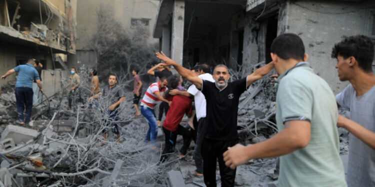 A Palestinian men react while a wounded girl is rescued from the rubble of a house after it was hit by Israeli strikes, in Khan Younis in the southern Gaza Strip, October 14, 2023. REUTERS/Yasser Qudih