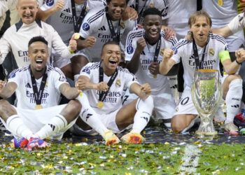 Real Madrid's Eder Militao, Kylian Mbappe, Vinicius Junior, and Luka Modric pose with the trophy after winning the UEFA Super Cup Final soccer match between Real Madrid and Atalanta at the Narodowy stadium in Warsaw, Poland, Wednesday, Aug. 14, 2024. Real Madrid won 2-0. (AP Photo/Darko Bandic)