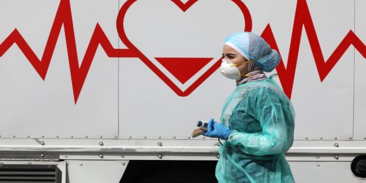 A Jordanian doctor walks next a mobile clinic that is operated as part of initiative that was launched with the aim of providing Jordanians with field medical services, amid concerns over the spread of the coronavirus disease (COVID-19), in Amman, Jordan, March 30, 2020. Picture taken March 30, 2020. REUTERS/Muhammad Hamed - RC2YUF9FKPPE