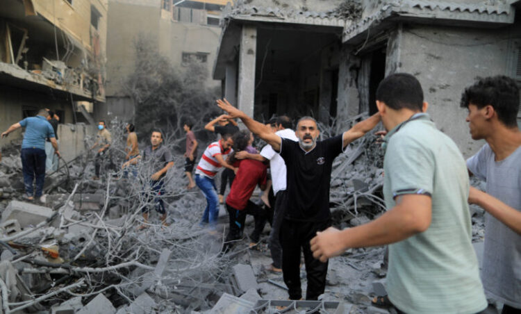 A Palestinian men react while a wounded girl is rescued from the rubble of a house after it was hit by Israeli strikes, in Khan Younis in the southern Gaza Strip, October 14, 2023. REUTERS/Yasser Qudih