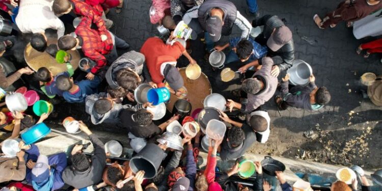 Palestinians gather to receive food cooked by a charity kitchen, amid the ongoing conflict between Israel and the Palestinian Islamist group Hamas, in Rafah in the southern Gaza Strip December 17, 2023. REUTERS/Shadi Tabatibi