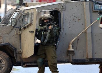 An Israeli soldier gestures on December 13, 2023 following an overnight army raid in Jenin in the occupied West Bank, as battles continue between Israel and the militant movement Hamas in Gaza. Israeli forces killed four Palestinians in Jenin on December 12, the Palestinian health ministry reported without further details on the fatalities, while the Palestinian Red Crescent Society said they were killed in a drone strike in the old town. (Photo by Jaafar ASHTIYEH / AFP)