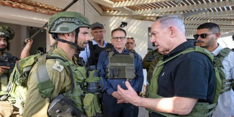 HANDOUT - 14 October 2023, Israel, Kibbutz Be'eri: Israel's Prime Minister Benjamin Netanyahu (L) speaks to a member of the IDF during his visit to Kibbutz Be'eri and Kibbutz Kfar Aza. Photo: Avi Ohayon/GPO/dpa - ATTENTION: editorial use only and only if the credit mentioned above is referenced in full