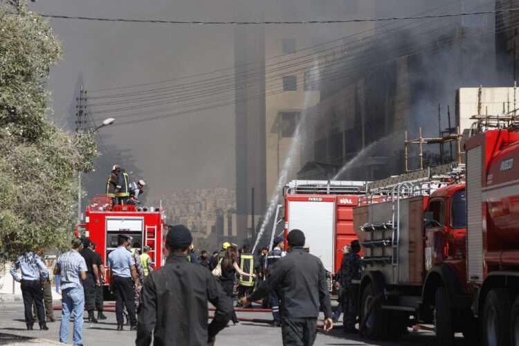 Firefighters extinguish a fire at a wing of a private hospital, which is under construction, in Amman August 5, 2013. Police said an electrical fault caused the massive fire in the Farah Hospital, which sent huge plumes of smoke into the sky and caused traffic to gridlock across Amman as fire engines rushed to the scenes. No casualties were reported but it took civil defence brigades hours to get the fire under control. REUTERS/Majed Jaber (JORDAN - Tags: DISASTER HEALTH)