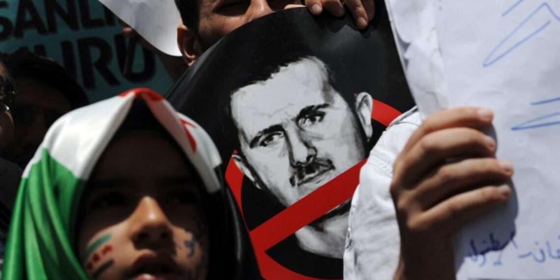 Demonstrators protest in front of the Syrian consulate in Istanbul on May 27, 2012 against the regime of Syrian President Bashar al-Assad. The head of a UN mission warned of "civil war" in Syria after his observers counted more than 92 bodies, 32 of them children, in Houla following reports of a massacre there. AFP PHOTO/BULENT KILIC (Photo by BULENT KILIC / AFP)