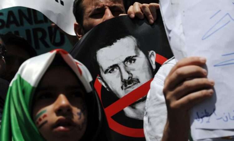 Demonstrators protest in front of the Syrian consulate in Istanbul on May 27, 2012 against the regime of Syrian President Bashar al-Assad. The head of a UN mission warned of "civil war" in Syria after his observers counted more than 92 bodies, 32 of them children, in Houla following reports of a massacre there. AFP PHOTO/BULENT KILIC (Photo by BULENT KILIC / AFP)
