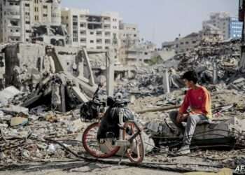 A Palestinian youth sits next to his bicycle amid the rubble of destroyed buildings in Gaza City on the northern Gaza strip following weeks of Israeli bombardment, as a four-day ceasefire took effect on November 24, 2023. The truce in the Israel-Hamas war began on November 24 and appeared to be holding, under a deal that will see hostages released in exchange for Palestinian prisoners. (Photo by AFP)